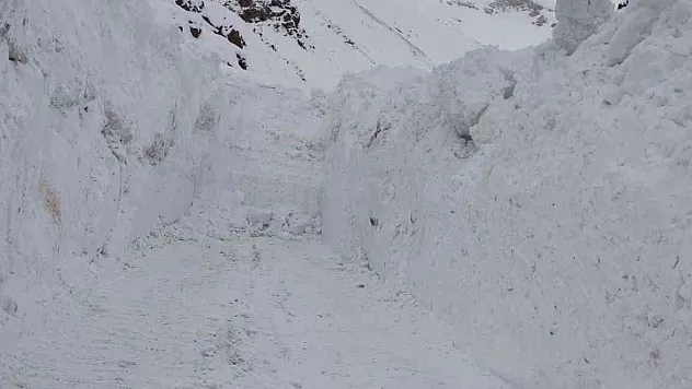 Kar kalınlığının iş makinelerinin boyunu geçtiği yolda zorlu çalışma
