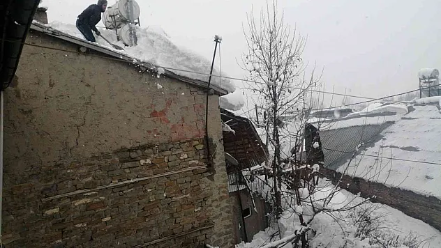 Arıcak'ta vatandaşlar, çatılarda biriken kar birikintilerini temizledi
