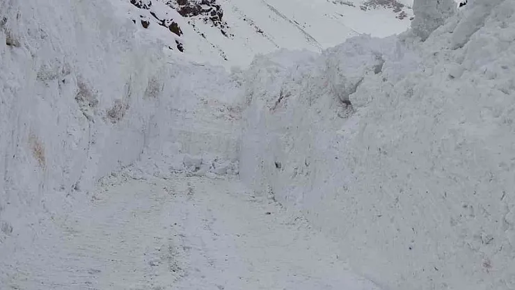 Kar kalınlığının iş makinelerinin boyunu geçtiği yolda zorlu çalışma
